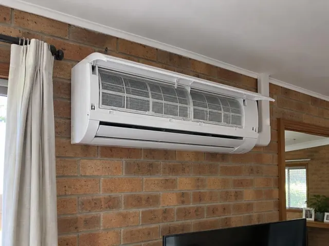 Clean split system on a brick wall with open front panel and visible filters in Salisbury East